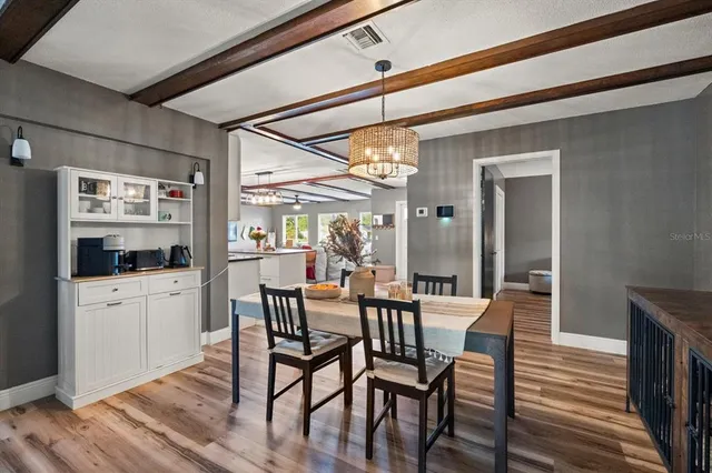 a dining room with furniture a chandelier and wooden floor