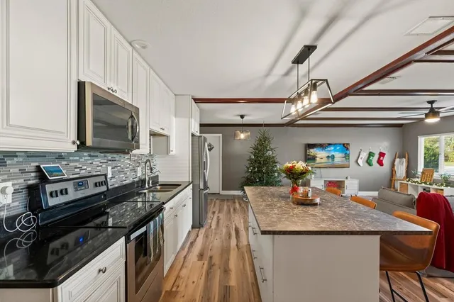 a kitchen with granite countertop a sink appliances and cabinets
