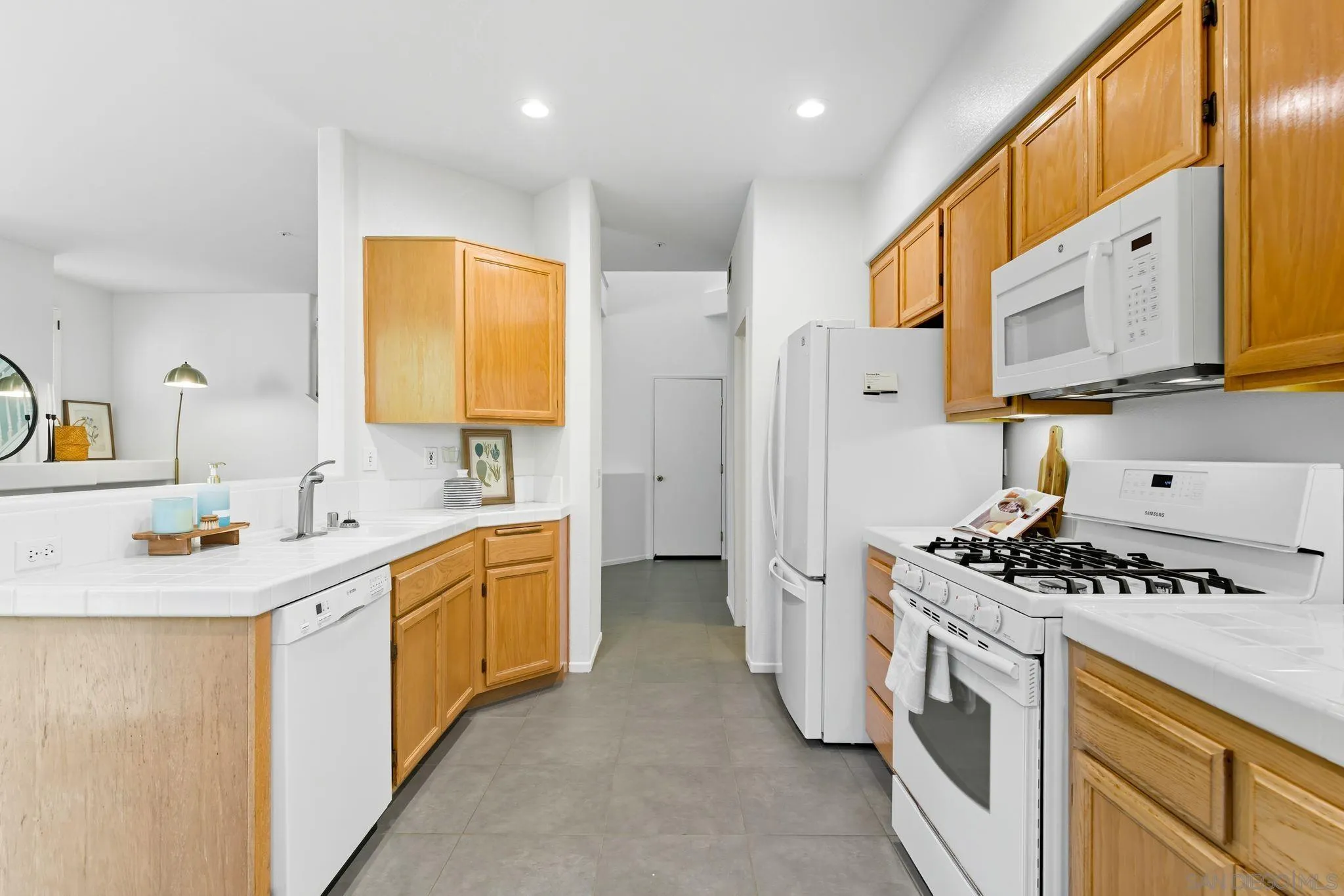 1802 Key Largo Road Vista, CA 92081 - Photo 8 of 24 a kitchen with stainless steel appliances a sink a stove a refrigerator cabinets and a window
