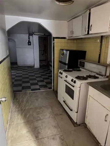 a kitchen with white cabinets and white appliances