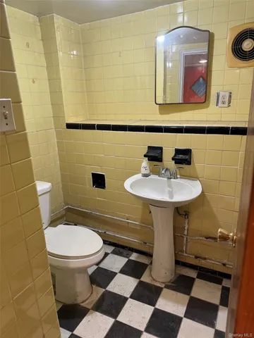 a bathroom with a sink toilet and mirror