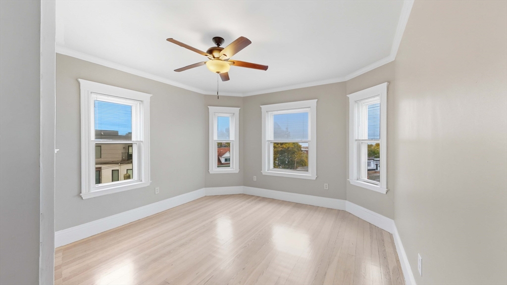 1 Orient Avenue, Unit 3C Boston, MA 02128 - Photo 12 of 25 a view of an empty room with a window and wooden floor