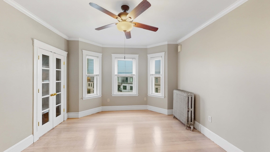 1 Orient Avenue, Unit 3C Boston, MA 02128 - Photo 13 of 25 an empty room with windows and fan