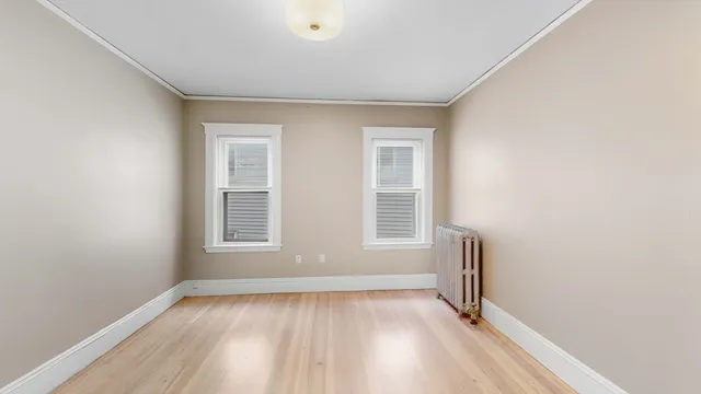 an empty room with wooden floor and ceiling fan