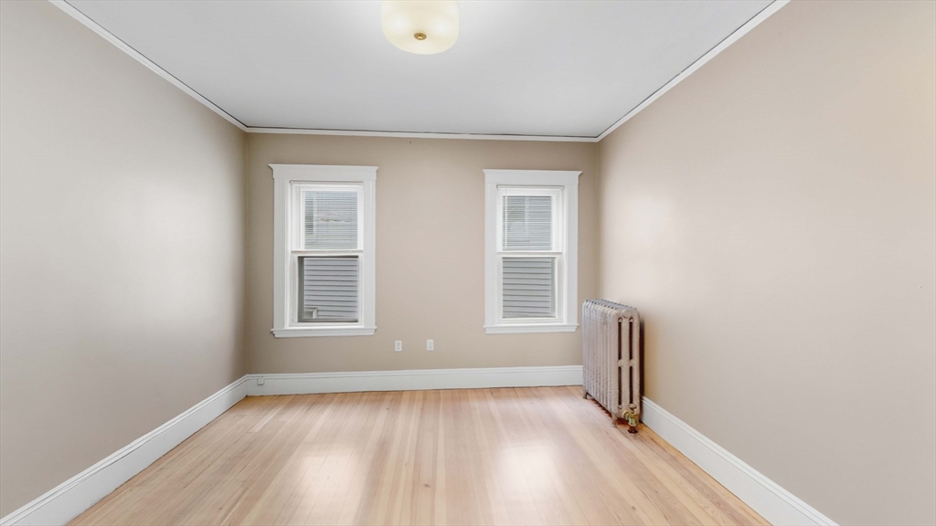 1 Orient Avenue, Unit 3C Boston, MA 02128 - Photo 14 of 25 an empty room with wooden floor and windows