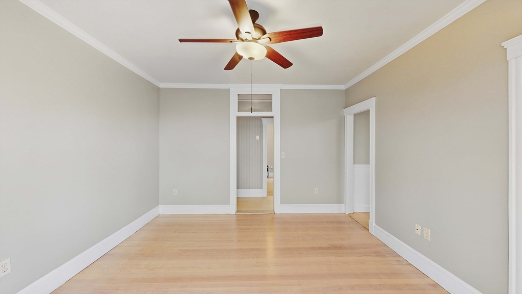 1 Orient Avenue, Unit 3C Boston, MA 02128 - Photo 15 of 25 an empty room with wooden floor and ceiling fan