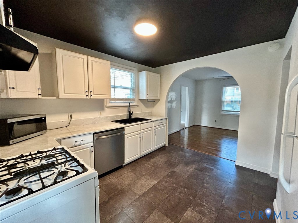 910 Forest View Drive Richmond, VA 23225 - Photo 3 of 23 a kitchen with stainless steel appliances a stove a sink and white cabinets