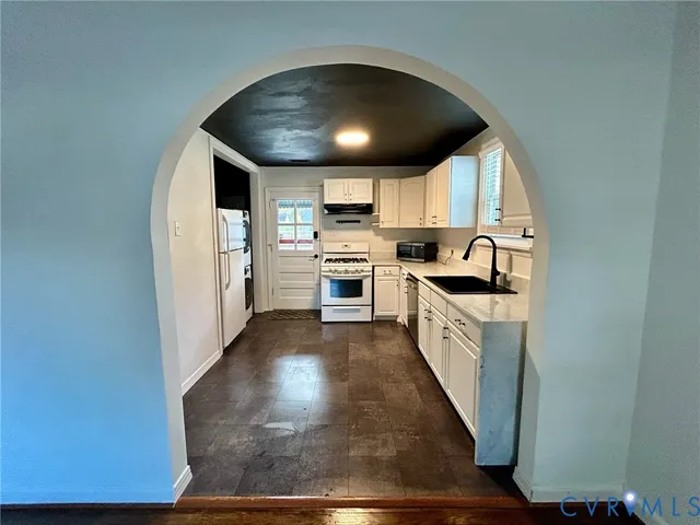 a large kitchen with a white stove top oven and sink
