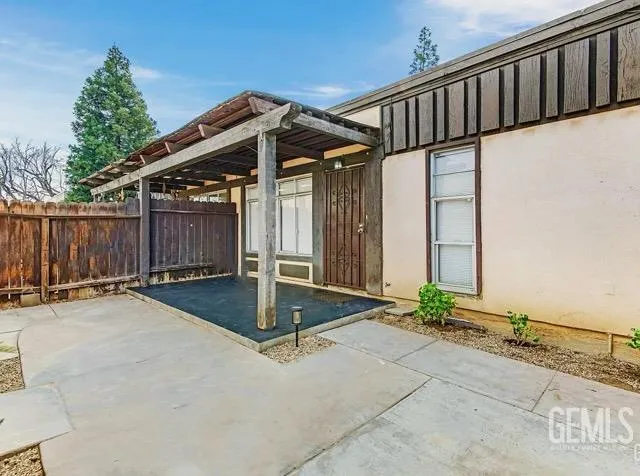 a view of a house with backyard and wooden fence