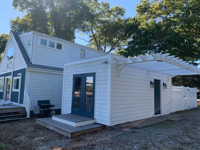 a view of a house with a yard and a large tree