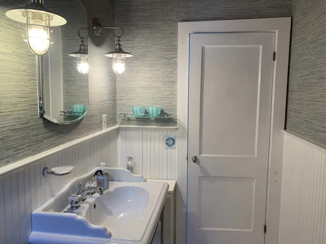 a bathroom with a sink a toilet and mirror