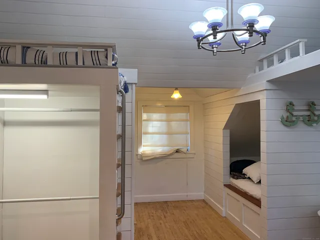 a view of a hallway with wooden floor and chandelier