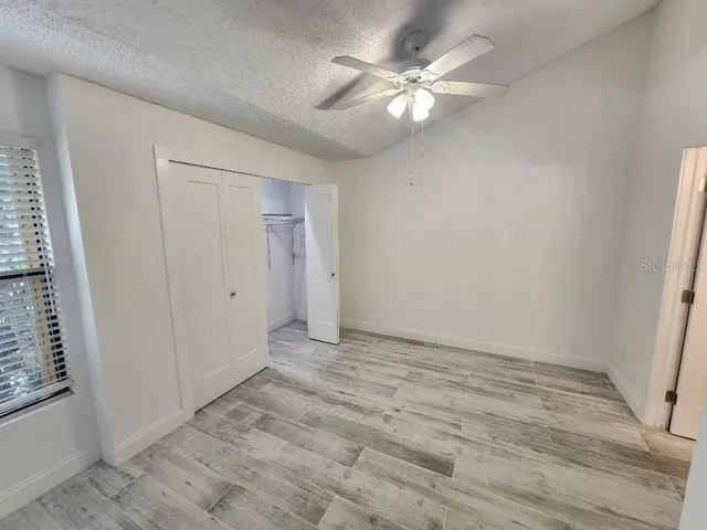 an empty room with fan and entrance