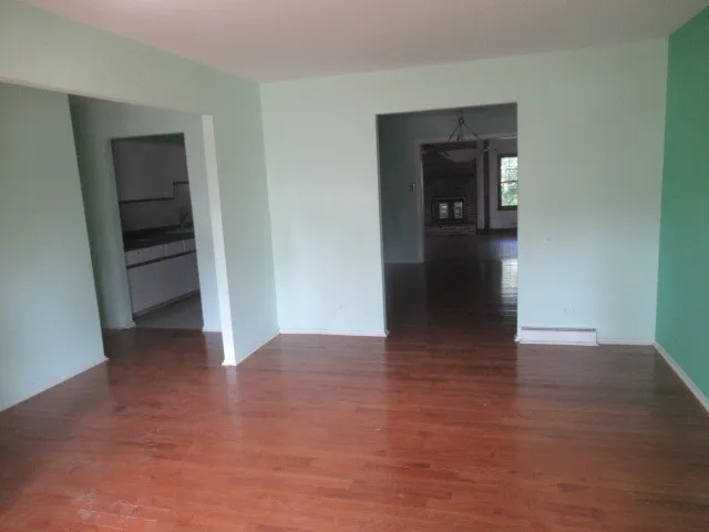 a view of a hallway with wooden floor and closet