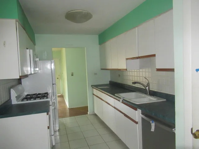 a kitchen with granite countertop a sink stove and refrigerator