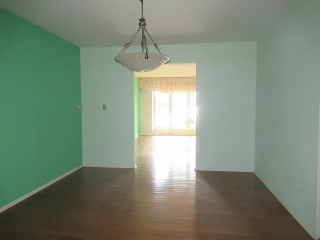 a view of a room with a window and wooden floor