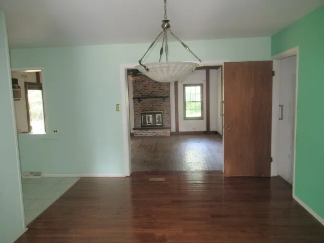 a view of a room with wooden floor staircase and a kitchen