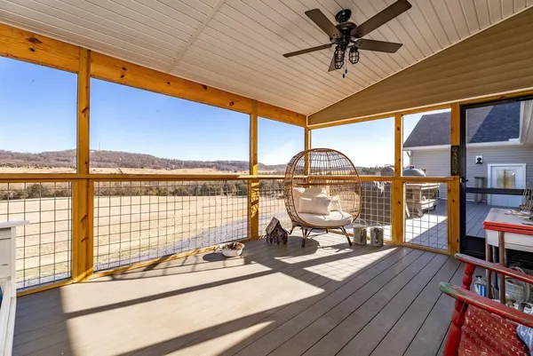 a view of a balcony with chairs and wooden floor