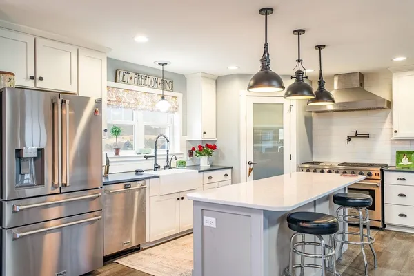 a open kitchen with stainless steel appliances granite countertop a sink a stove a dining table and chairs