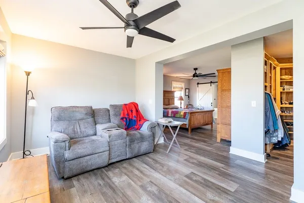 a living room with furniture a rug and wall paintings