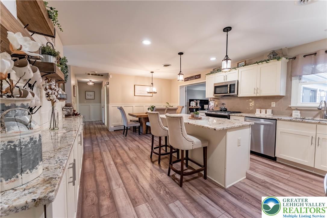 345 South Whitfield Street Nazareth, PA 18064 - Photo 6 of 29 a kitchen with stainless steel appliances a refrigerator a stove a sink dishwasher and white cabinets with wooden floor