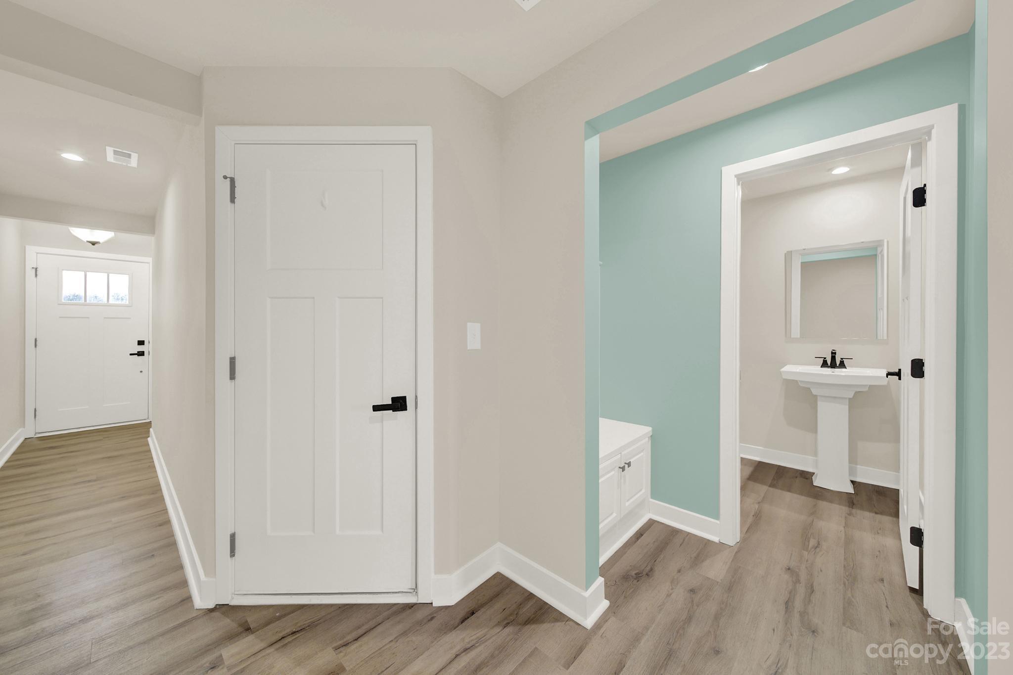 930 Portrush Lane Tega Cay, SC 29708 - Photo 8 of 40 a view of a hallway with wooden floor and a bathroom