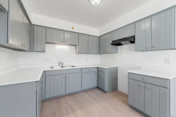 a kitchen with sink cabinets and wooden floor