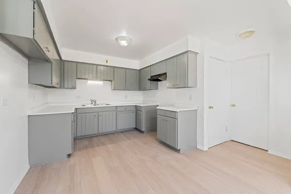 a kitchen with a sink cabinets and wooden floor