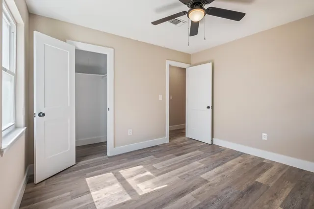 a view of an empty room with wooden floor