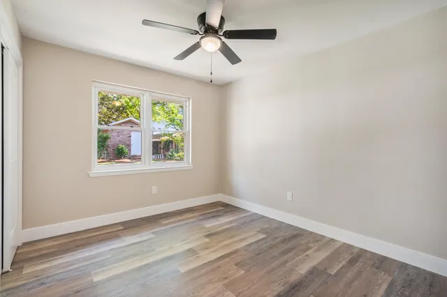 a view of empty room with window and ceiling fan