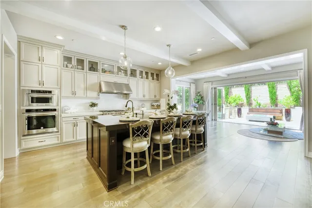 a kitchen with stainless steel appliances kitchen island granite countertop a table chairs and a refrigerator
