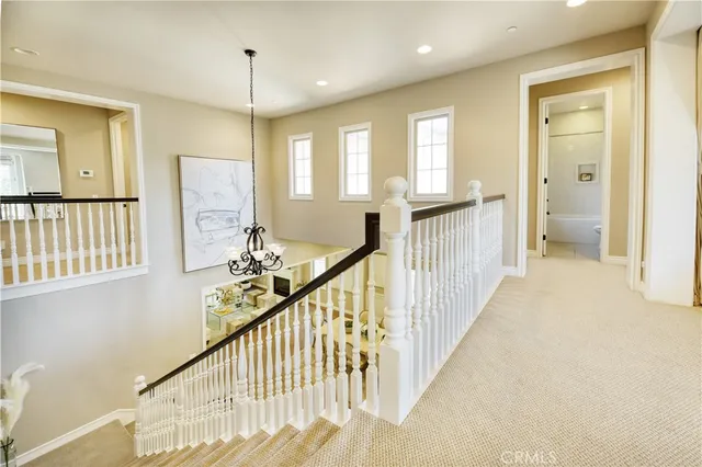 a view of a hallway with wooden floor and windows