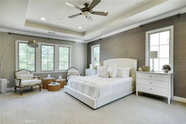 a spacious bedroom with a bed and large windows