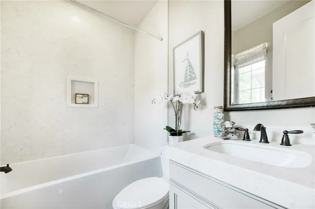 a spacious bathroom with a double vanity sink a large mirror a bathtub and shower