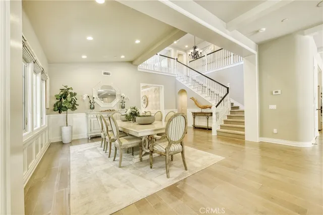 a dining room with wooden floor and a chandelier
