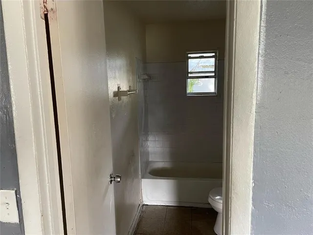 a view of a house with a yard and large trees