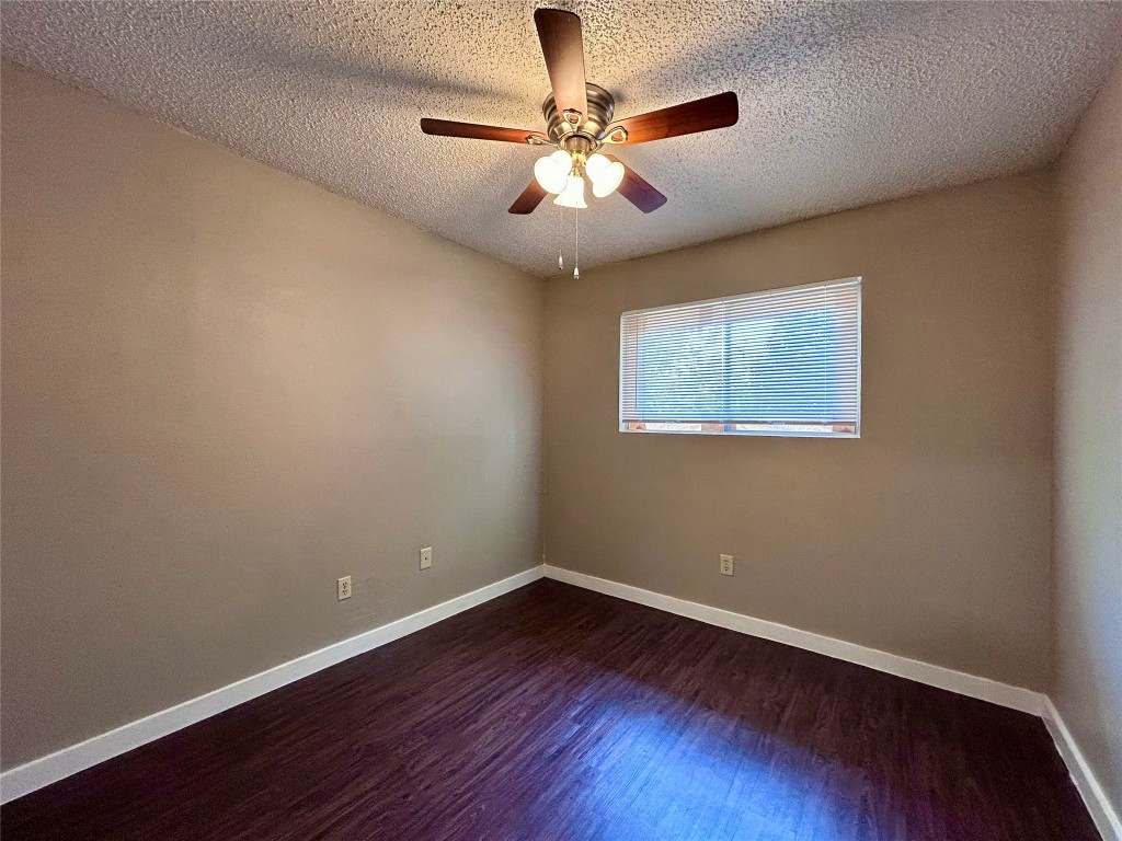 1500 No Mor Cove, Unit B Austin, TX 78758 - Photo 13 of 17 a view of an empty room with wooden floor and a ceiling fan