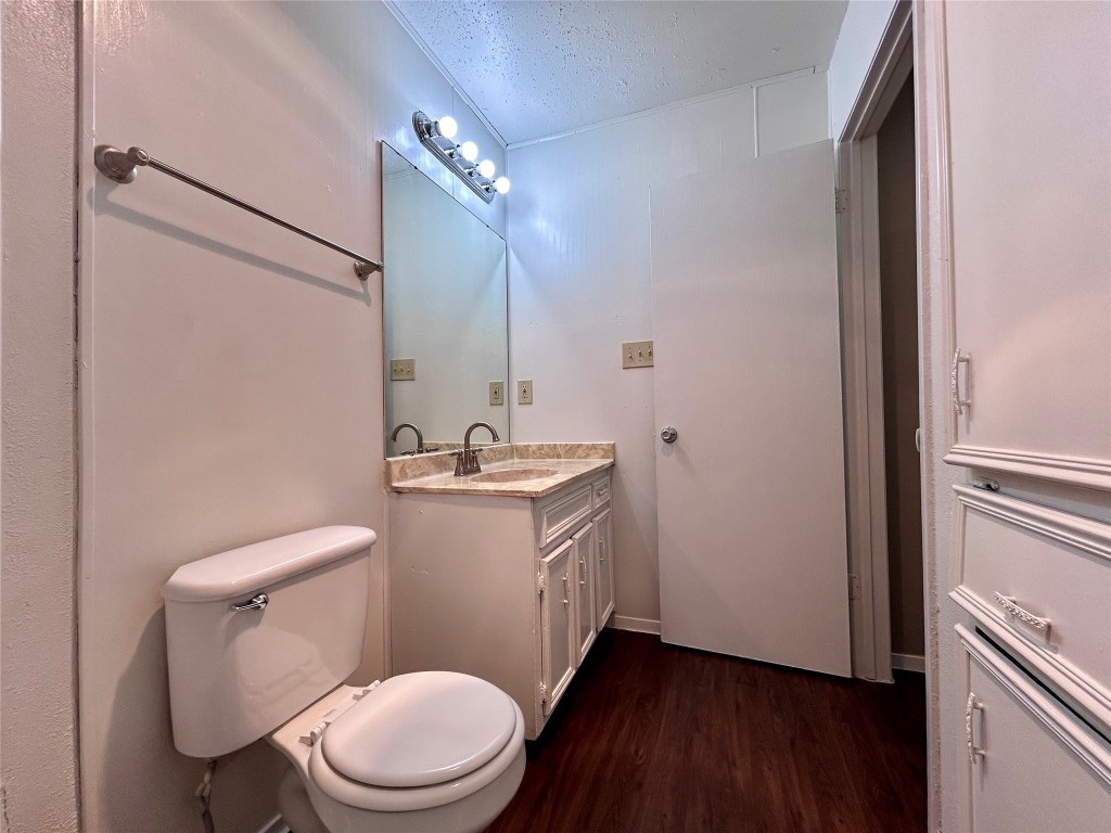 1500 No Mor Cove, Unit B Austin, TX 78758 - Photo 16 of 17 a bathroom with a toilet a sink and wooden floor