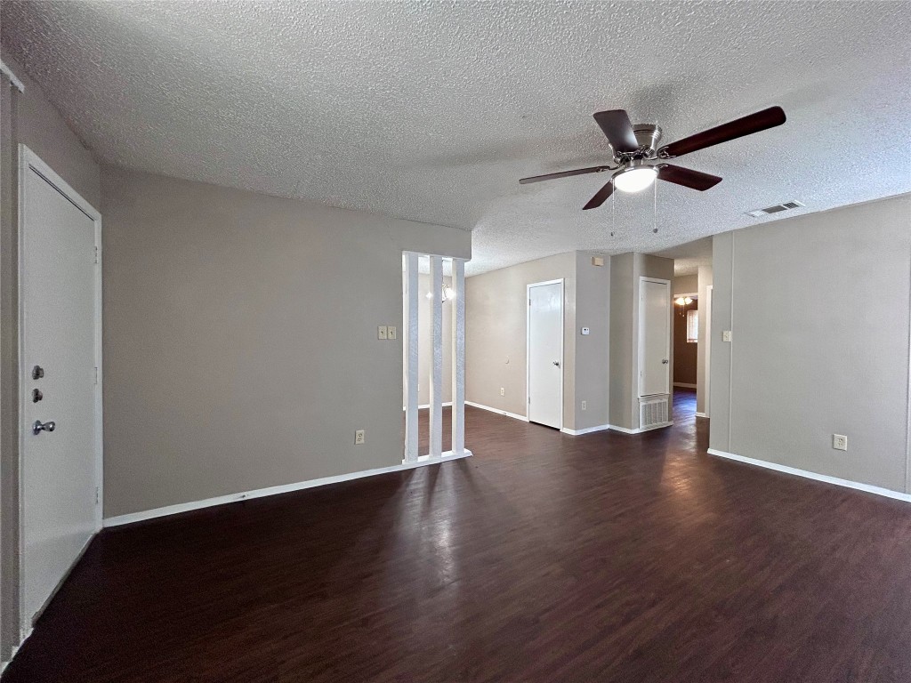 1500 No Mor Cove, Unit B Austin, TX 78758 - Photo 5 of 17 a view of an empty room with wooden floor and a ceiling fan