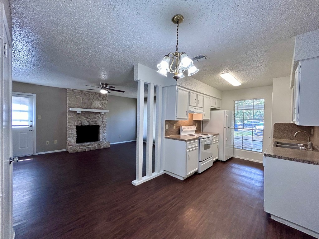 1500 No Mor Cove, Unit B Austin, TX 78758 - Photo 6 of 17 a kitchen with stainless steel appliances granite countertop a refrigerator a stove oven a sink dishwasher and white cabinets with wooden floor