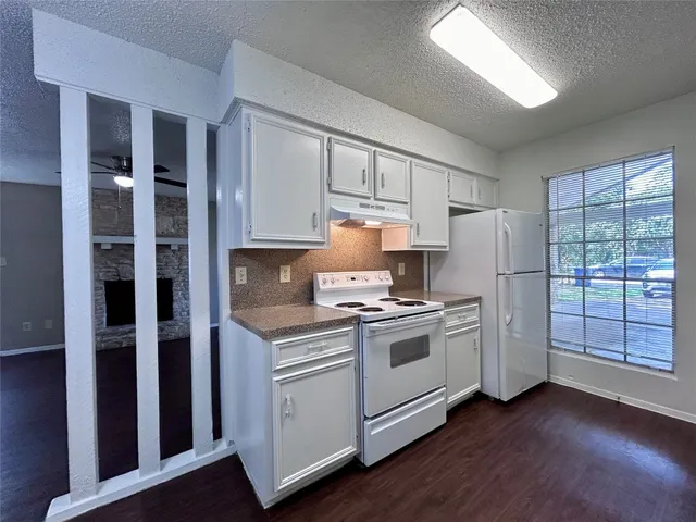 a kitchen with stainless steel appliances granite countertop a stove a refrigerator and a cabinets