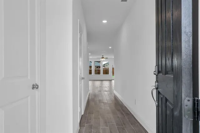 a view of a hallway with wooden floor and staircase