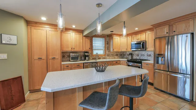a kitchen with a refrigerator a sink and chairs