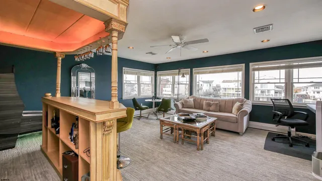a living room with furniture a flat screen tv and a large window