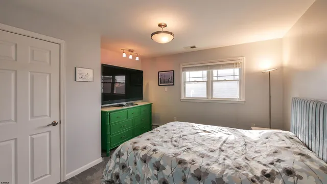 a bedroom with bed and flat screen tv