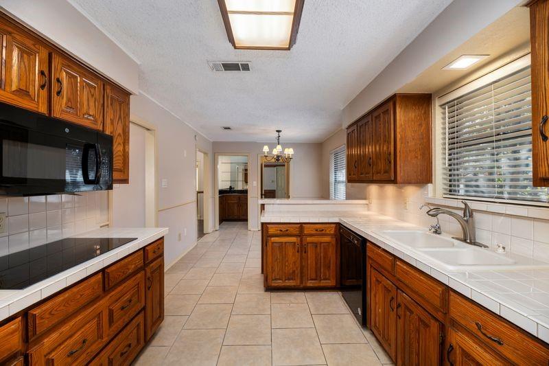 922 Kingston Drive Mansfield, TX 76063 - Photo 16 of 24 a kitchen with stainless steel appliances granite countertop a sink and a microwave