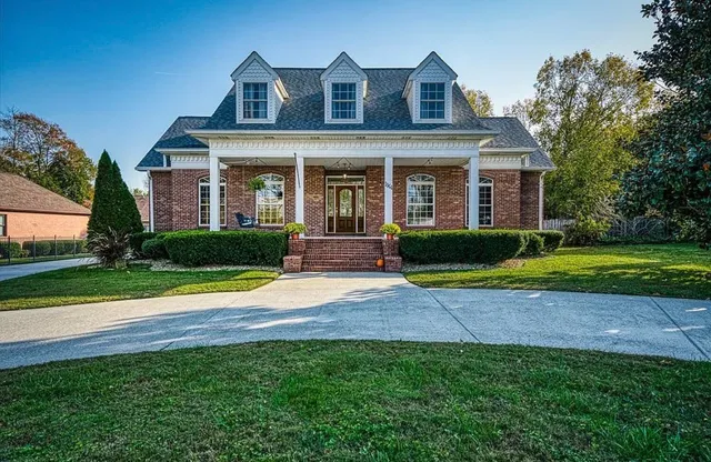 a view of a brick house with a yard and potted plants