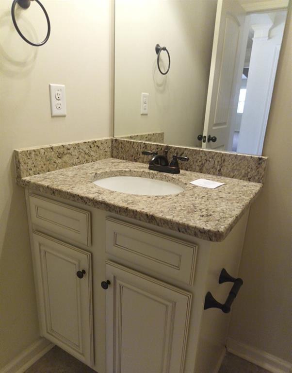 307 Cinnamon Bark Pass Locust Grove, GA 30248 - Photo 22 of 26 a bathroom with a granite countertop sink and a mirror