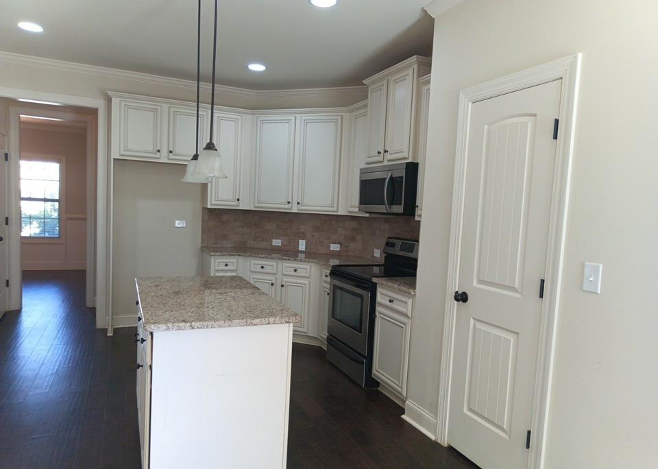 307 Cinnamon Bark Pass Locust Grove, GA 30248 - Photo 7 of 26 a kitchen with a refrigerator a sink and cabinets