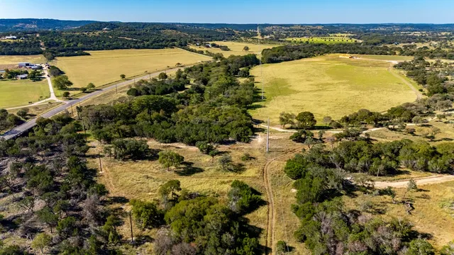 a view of a lake with beach and large trees